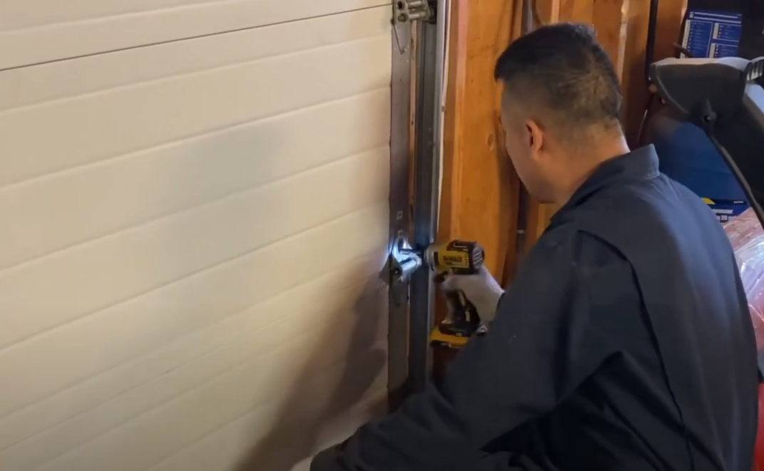 Professional technician replacing a garage door section with tools and equipment, showcasing garage door section replacement service by Alum Creek Garage Doors Repair.