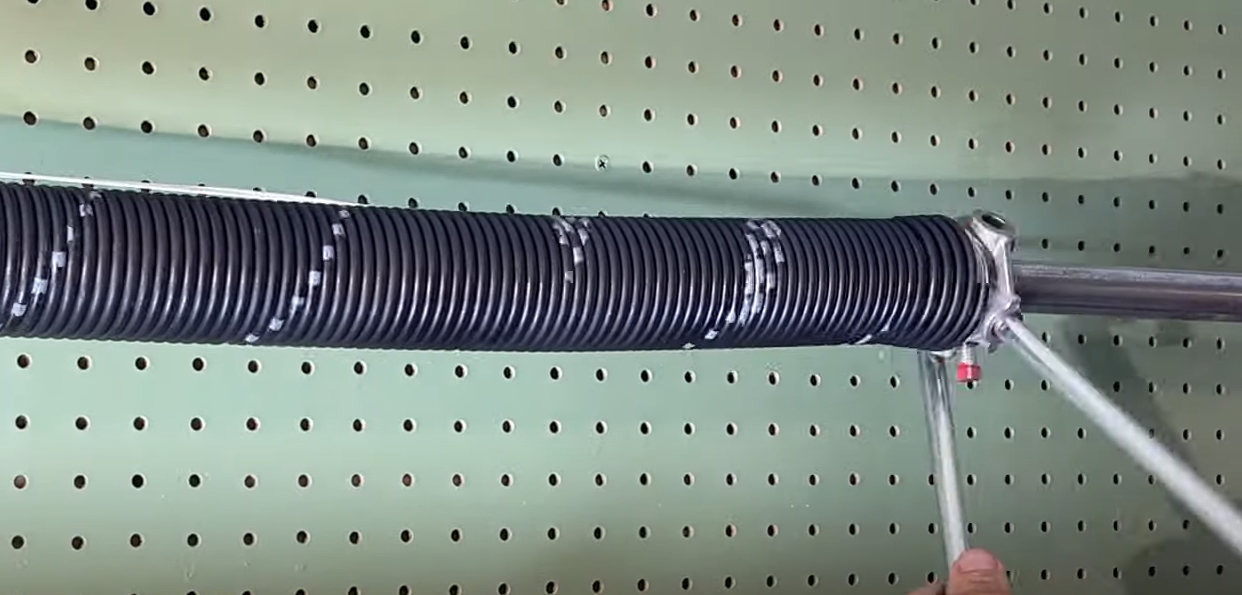 A professional technician performing garage door spring repair on a residential garage door, showcasing tools and expertise at Alum Creek Garage Doors Repair.