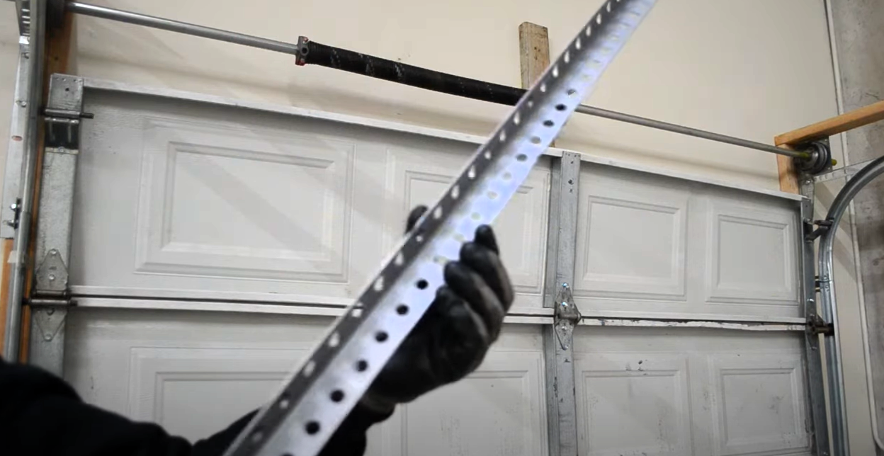 Technician performing garage door track repair on a residential garage door to ensure smooth operation.