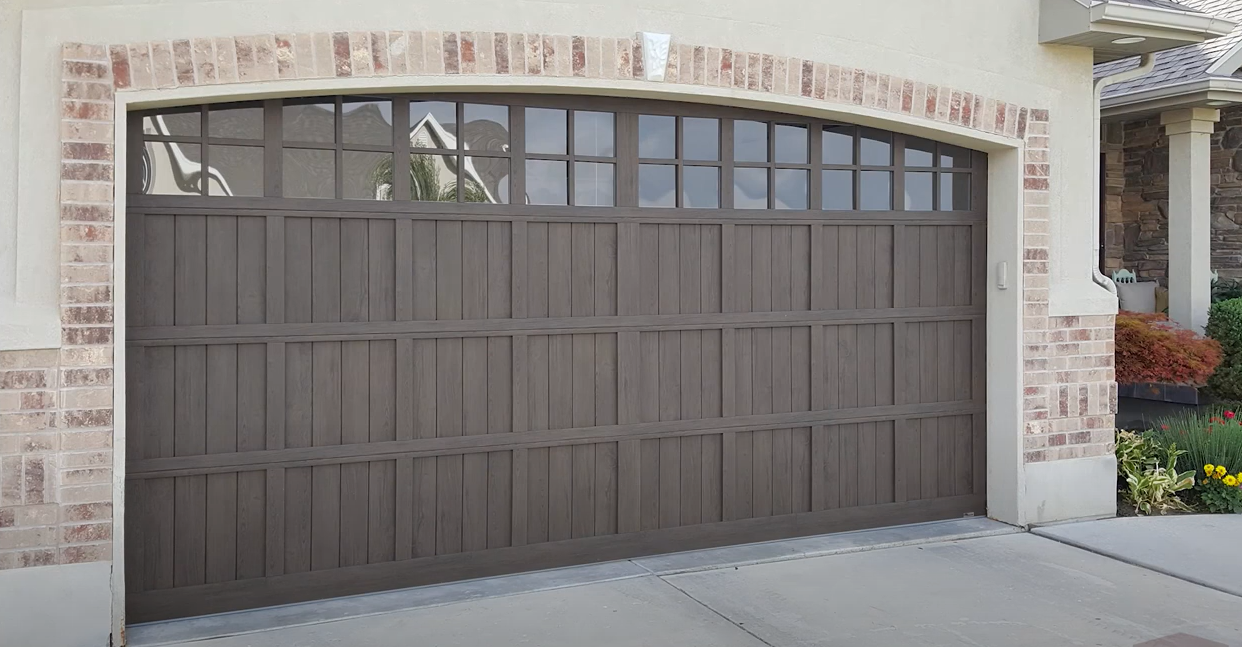 Technician performing a garage door panel repair on a residential aluminum garage door, ensuring smooth functionality and appearance.