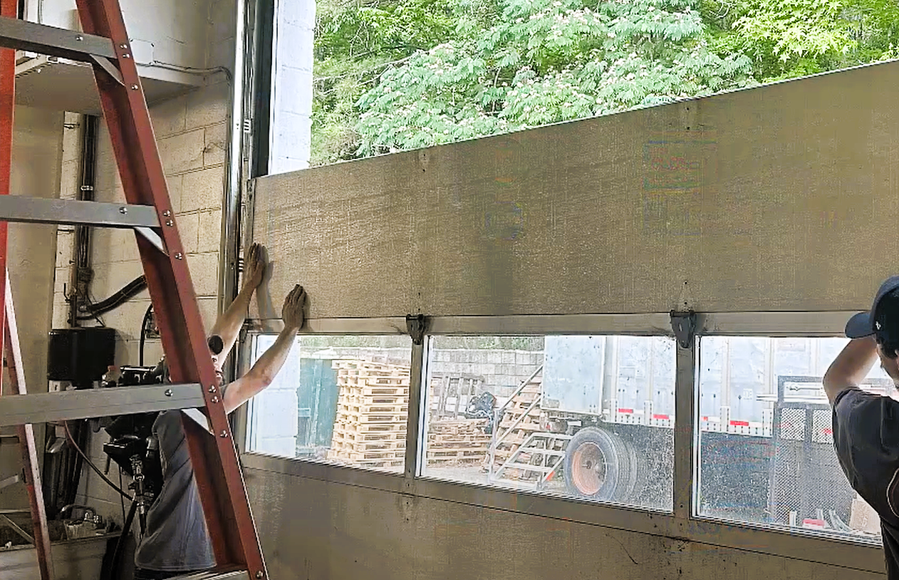 Technician performing garage door panel repair on a residential garage door at Alum Creek, showcasing detailed repair tools and techniques.