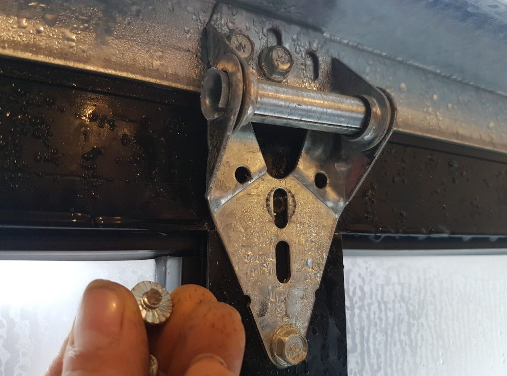 Technician repairing a noisy garage door with tools in a residential garage, highlighting Alum Creek Garage Doors Repair services.