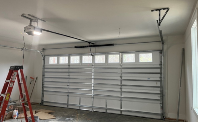 Technician providing local garage door repair services at a residential home, showcasing professional tools and equipment for high-quality maintenance.