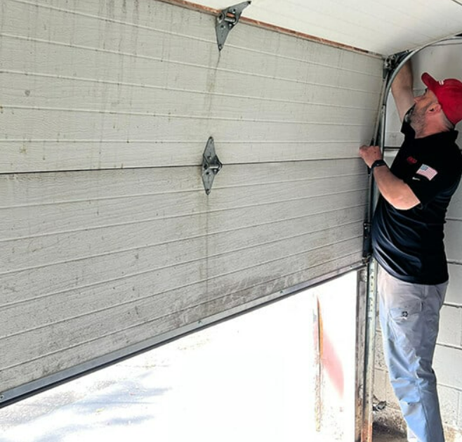 A professional technician from Alum Creek Garage Doors Repair inspecting a garage door mechanism to prolong its lifespan.