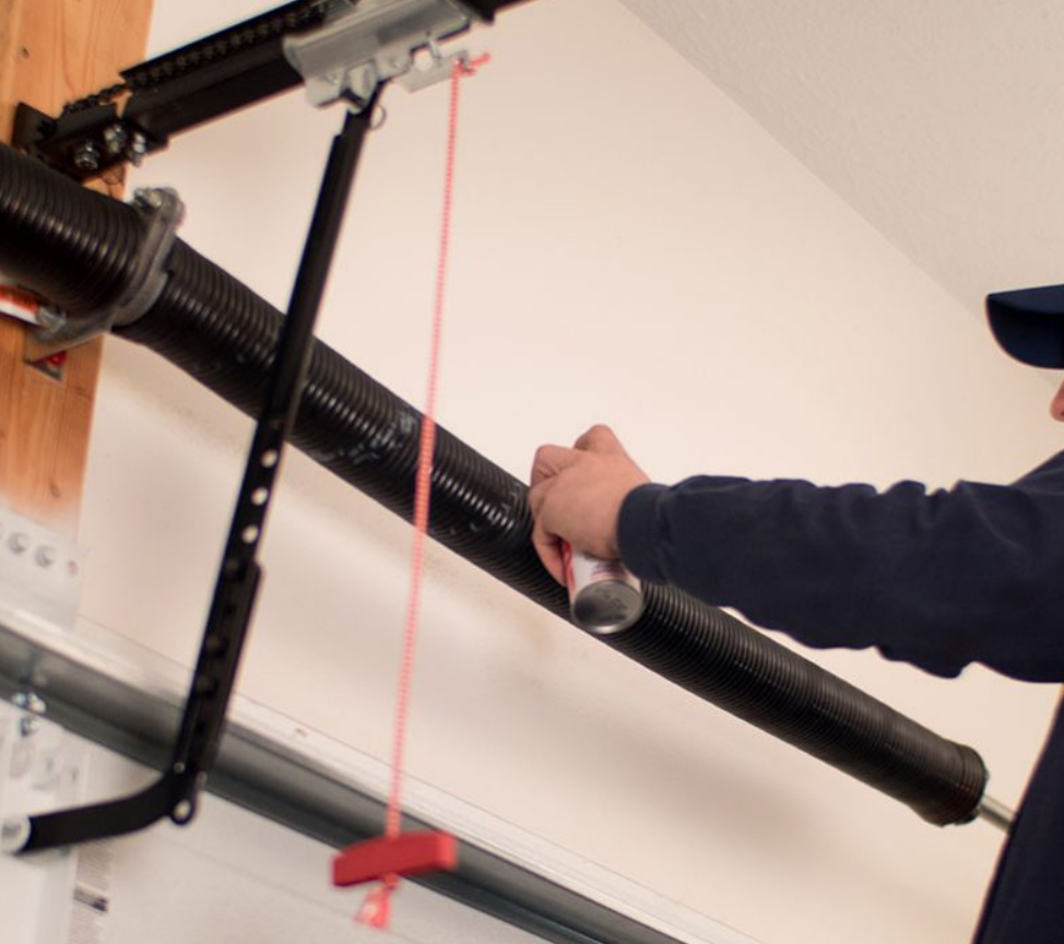 echnician performing a garage door spring repair on a residential garage, ensuring smooth and safe operation