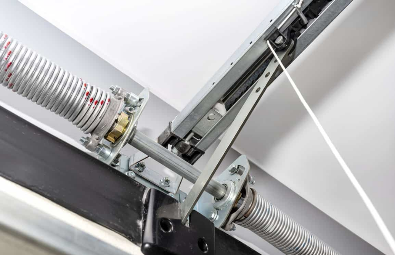 Technician performing garage door spring repair on a residential overhead garage door, showcasing tools and expertise from Alum Creek Garage Doors Repair.