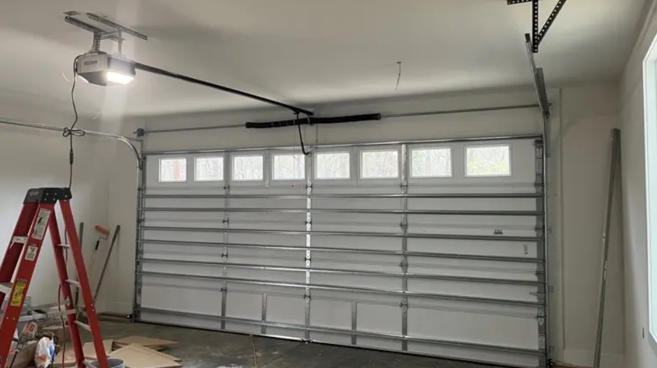 Technician performing same-day garage door repair on a modern white sectional garage door in a residential home, ensuring quick and reliable service
