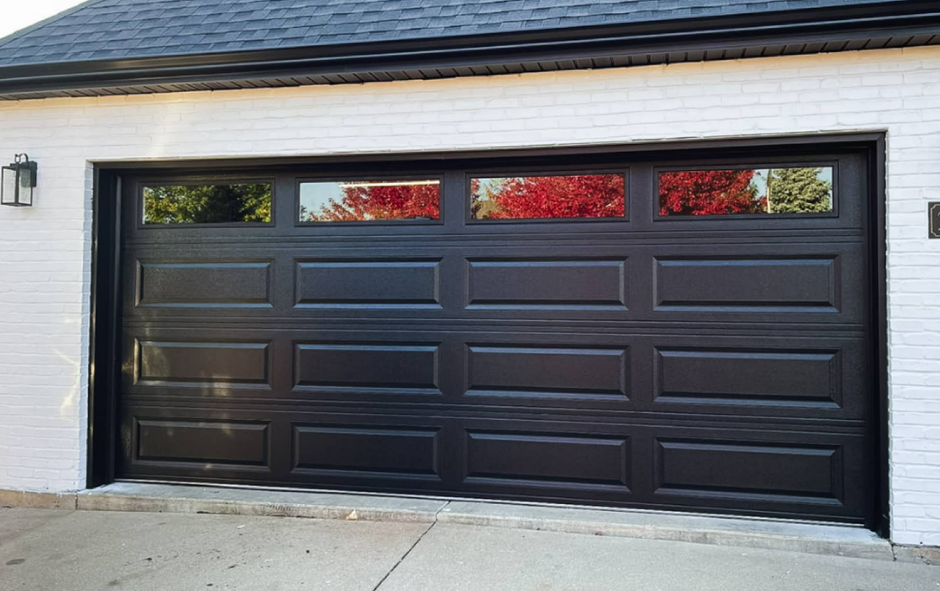 Custom wooden garage door with sleek modern design, featuring horizontal paneling and black hardware, installed by Alum Creek Garage Doors Repair.