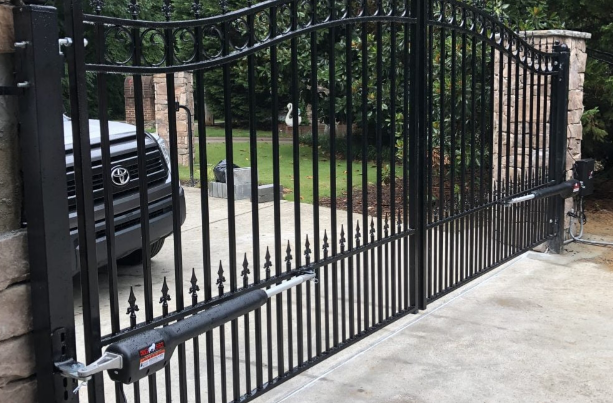 Technician repairing a residential gate with professional tools, showcasing expert residential gate repair services by Alum Creek Garage Doors Repair.
