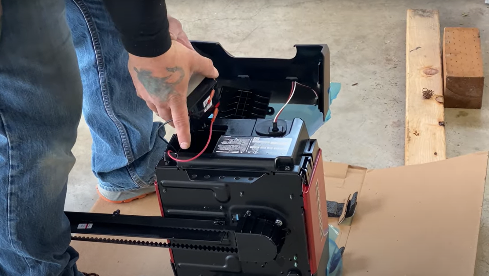 Close-up image of a technician from Alum Creek Garage Doors Repair working on a garage door opener mechanism. The photo showcases detailed tools and components, highlighting the professional repair service offered by the business.
